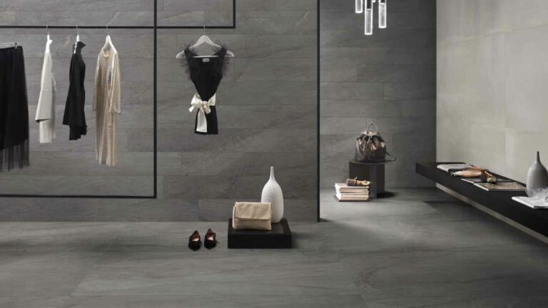 Carrelage en céramique sombre d'Éco Ceramik présenté dans un élégant espace de boutique, mettant en valeur des vêtements et accessoires de mode.