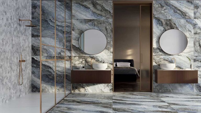 Salle de bain raffinée avec des murs et un sol en carrelage effet marbre d'Éco Ceramik, accentués par des accessoires dorés et une vanité moderne.