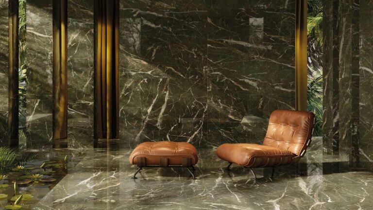 Intérieur somptueux avec carrelage et murs effet marbre vert d'Éco Ceramik, agrémenté de fauteuils en cuir et de végétation tropicale.