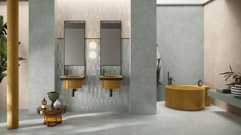 Salle de bain moderne avec carrelage en grès cérame, baignoire ronde jaune et lavabos suspendus de couleur coordonnée.